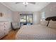 Light-filled bedroom with a view of the pool area, hardwood floors, and a comfortable seating area at 10812 96Th St, Largo, FL 33773
