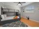 Bedroom with bunk beds, hardwood floors, ceiling fan, and a bright sunny window at 10812 96Th St, Largo, FL 33773