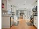 Bright kitchen featuring stainless steel appliances, white cabinetry, an island, and stylish tile backsplash at 10812 96Th St, Largo, FL 33773