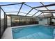 View of a screened-in pool and patio with outdoor furniture and a safety fence at 10812 96Th St, Largo, FL 33773