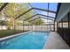 View of screened-in pool in backyard with pool deck and white vinyl fence at 10812 96Th St, Largo, FL 33773