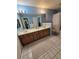 Bright bathroom with double vanity, tile floors, and shower with white curtain at 10825 Venice Cir, Tampa, FL 33635