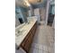 Bright bathroom with double vanity, tile floors, and shower with white curtain at 10825 Venice Cir, Tampa, FL 33635