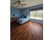 Well-lit bedroom with hardwood floors, ceiling fan, and window with blinds at 10825 Venice Cir, Tampa, FL 33635