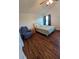 Bright bedroom with dark wood floors, sitting chair, and neutral decor at 10825 Venice Cir, Tampa, FL 33635
