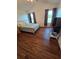Bright bedroom with dark wood floors, two windows, and neutral decor at 10825 Venice Cir, Tampa, FL 33635
