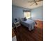 Well-lit bedroom with hardwood floors, ceiling fan, and window with blinds at 10825 Venice Cir, Tampa, FL 33635