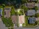 Aerial view of the property showing the roof, driveway, and surrounding greenery and neighboring houses at 1211 Penny Ct, Dunedin, FL 34698