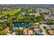Picturesque aerial view of home with a pond, green spaces, and views of the surrounding neighborhood at 1211 Penny Ct, Dunedin, FL 34698