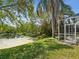 Backyard view with a serene pond and screened lanai, offering a peaceful outdoor setting at 1211 Penny Ct, Dunedin, FL 34698