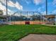A well-maintained baseball field sits under a bright blue sky, surrounded by lush green grass at 1211 Penny Ct, Dunedin, FL 34698
