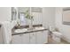Bright bathroom featuring double sinks, white cabinets, and a toilet at 1211 Penny Ct, Dunedin, FL 34698
