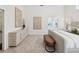 Elegant bedroom featuring high ceilings, modern artwork, and a cozy bench creating a serene and stylish space at 1211 Penny Ct, Dunedin, FL 34698