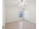 Bright bedroom featuring a window with blinds, a closet, and neutral tile floors at 1211 Penny Ct, Dunedin, FL 34698