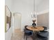 Dining room features a round wooden table with gray upholstered chairs and modern artwork at 1211 Penny Ct, Dunedin, FL 34698