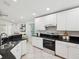 Modern kitchen featuring white cabinets, stainless steel appliances, and sleek countertops at 1211 Penny Ct, Dunedin, FL 34698