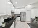 Modern kitchen features stainless steel appliances, granite countertops, and ample white cabinetry at 1211 Penny Ct, Dunedin, FL 34698