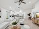 Open-concept living room with kitchen island, ceiling fan, and neutral decor at 1211 Penny Ct, Dunedin, FL 34698