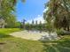 Scenic pond view surrounded by lush greenery, showcasing the property's tranquil and picturesque setting at 1211 Penny Ct, Dunedin, FL 34698