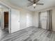 Bedroom featuring gray wood-look floors, ceiling fan, and closet. Doorways lead to other rooms at 12400 Park Blvd # 121, Seminole, FL 33772