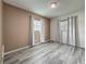 Empty bedroom with neutral paint, gray wood-look floors, and window with curtains at 12400 Park Blvd # 121, Seminole, FL 33772