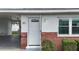 Inviting front entrance with a white door, brick accents, and convenient carport access at 12400 Park Blvd # 121, Seminole, FL 33772
