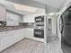 A bright kitchen with white cabinets, granite countertops, tile backsplash and stainless appliances at 12400 Park Blvd # 121, Seminole, FL 33772
