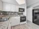 Updated kitchen showcasing stainless appliances, granite counters, mosaic backsplash and white cabinetry at 12400 Park Blvd # 121, Seminole, FL 33772