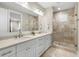 Bathroom with a double sink vanity, tiled floors, and a glass enclosed shower at 1511 47Th N Ave, St Petersburg, FL 33703
