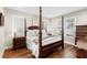 This bedroom features a four-poster bed, shuttered windows, and hardwood flooring at 1511 47Th N Ave, St Petersburg, FL 33703