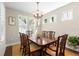 Elegant dining room featuring a wooden table, stylish chandelier, and bright windows with plantation shutters at 1511 47Th N Ave, St Petersburg, FL 33703