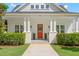 Inviting front porch featuring a vibrant red door framed by lush greenery and classic columns at 1511 47Th N Ave, St Petersburg, FL 33703