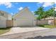 Exterior view of a detached garage with an automatic door and side entrance in a well-kept backyard at 1511 47Th N Ave, St Petersburg, FL 33703
