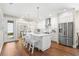 Modern white kitchen boasts stainless steel appliances, bright lighting, and seamlessly blends with dining area at 1511 47Th N Ave, St Petersburg, FL 33703