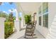 Charming porch with rocking chairs, surrounded by well-maintained landscaping and a glimpse of palm trees at 1511 47Th N Ave, St Petersburg, FL 33703