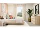 Comfortable bedroom with large windows, dresser with plants, and soft natural light at 15276 Rainbow Quartz St, Wimauma, FL 33598