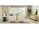 Inviting living room with plush seating, neutral tones, and abundant natural light from large windows at 15276 Rainbow Quartz St, Wimauma, FL 33598