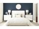 Bedroom showcases white furniture, a plush bed, dark blue wall, and stylish decor at 15276 Rainbow Quartz St, Wimauma, FL 33598