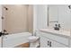 Bathroom featuring modern tub and tile surround, single sink vanity, and bright lighting at 17920 Nadine Pl, Nokomis, FL 34275