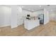 Bright kitchen with white cabinets, an island, stainless steel appliances, and wood-look tile flooring at 17920 Nadine Pl, Nokomis, FL 34275