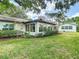 Beautiful backyard featuring a screen enclosed porch, lush lawn, and attractive landscaping at 2011 Halidom Way # 0, Sun City Center, FL 33573