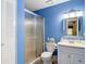 Fresh bathroom with a glass-enclosed shower, white vanity, and sleek lighting against vibrant blue walls at 2011 Halidom Way # 0, Sun City Center, FL 33573