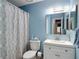 Stylish bathroom with blue walls, shower with patterned curtain, white vanity, and modern fixtures at 2011 Halidom Way # 0, Sun City Center, FL 33573