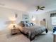 Well-lit bedroom featuring matching nightstands with lamps, a ceiling fan, and a large white dresser at 2011 Halidom Way # 0, Sun City Center, FL 33573