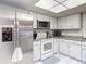 Bright kitchen with stainless steel refrigerator and microwave oven, and white cabinets at 2011 Halidom Way # 0, Sun City Center, FL 33573