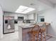 Bright kitchen features stainless steel appliances, granite counters, and wooden bar stools at 2011 Halidom Way # 0, Sun City Center, FL 33573