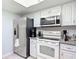 Well-lit kitchen featuring stainless steel refrigerator and white cabinets at 2011 Halidom Way # 0, Sun City Center, FL 33573