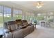 Relaxing sunroom with a plush reclining sofa, large windows, and serene views of the surrounding greenery at 2011 Halidom Way # 0, Sun City Center, FL 33573