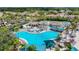 Overhead shot showcasing community pool, offering ample seating, palm trees, shaded umbrellas and tennis court access at 2011 Halidom Way # 0, Sun City Center, FL 33573