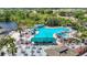 Aerial view showcasing the large, inviting community swimming pool with lounge chairs, tables, and lush tropical landscaping at 2011 Halidom Way # 0, Sun City Center, FL 33573